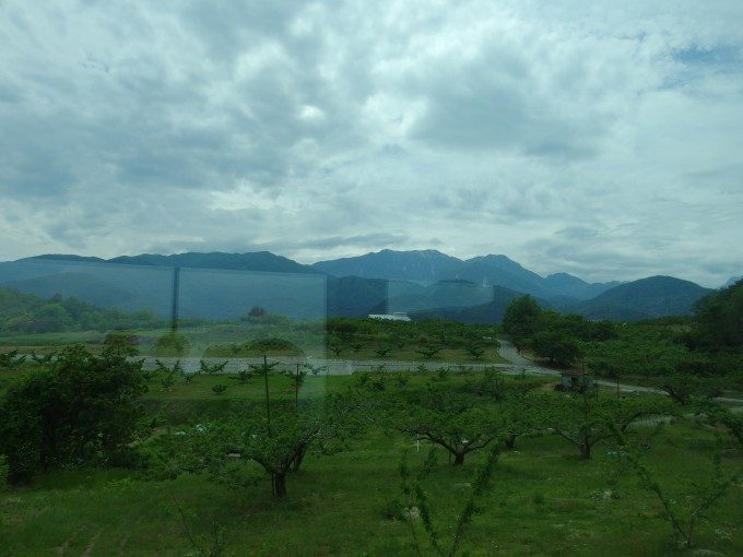 中央本線特急あずさ号車窓を彩る果樹園とアルプスの山