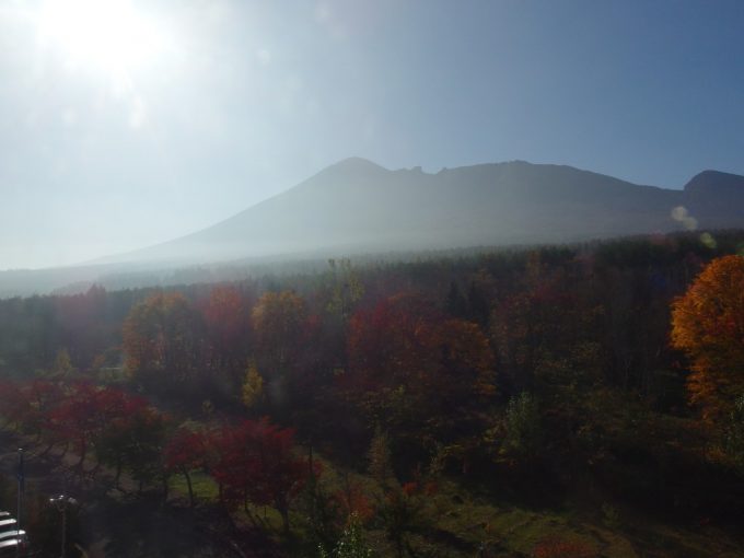晴れつつある朝霧と紅葉に包まれる岩手山