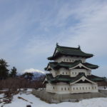 雪のない冬の弘前移設中の弘前城天守と優美な津軽富士