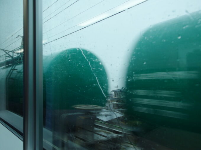 1月中旬E353系あずさ号雨の車窓すれ違う貨物列車タンク車を見送る
