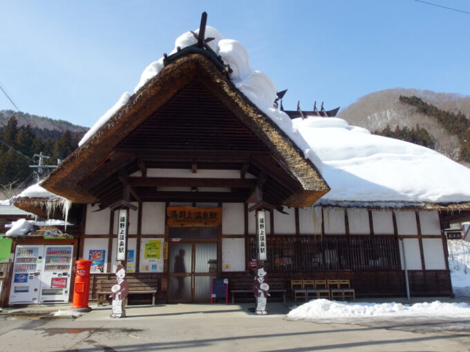 2月中旬冬の湯野上温泉茅葺屋根に白い雪の駅舎