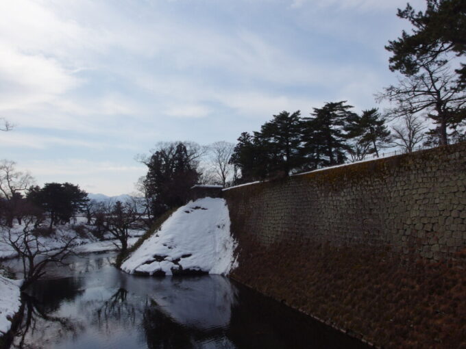 2月中旬冬の会津若松鶴ヶ城廊下橋から望む壁のような立派な石垣
