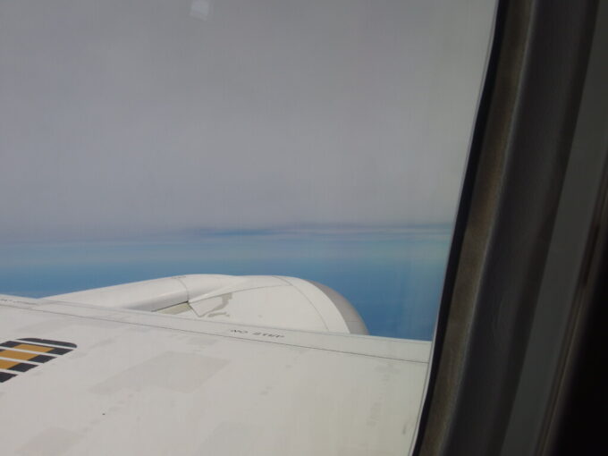 6月中旬全日空787那覇行き機窓から望む青い海