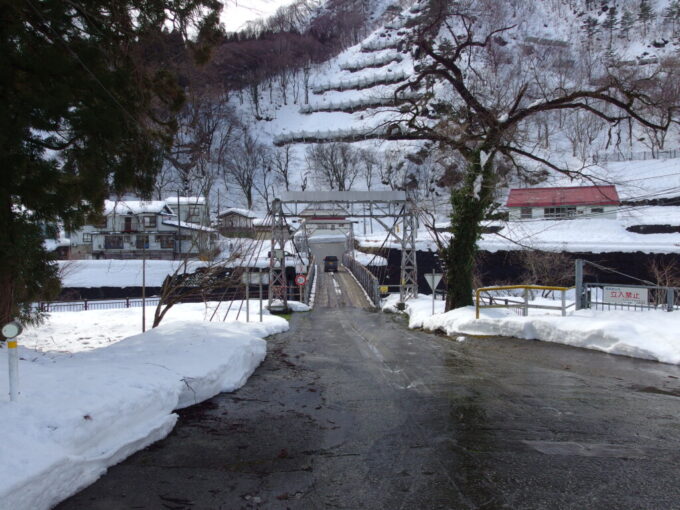 2月上旬姫川温泉湯の宿朝日荘姫川に架かる大網発電所専用道路路面が木製の吊り橋