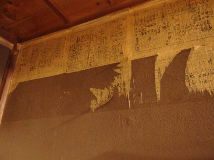 2月上旬信濃大町国の登録有形文化財平林家住宅塩の道ちょうじや廊下に残る古い帳簿を使用した壁の修復跡
