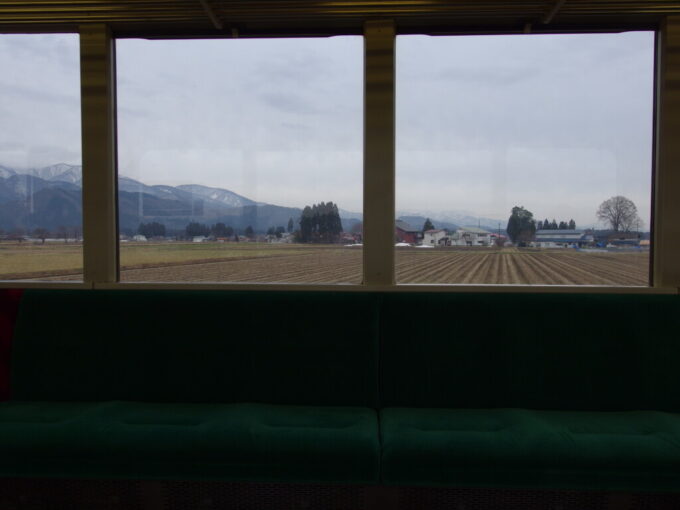 3月中旬春まだ浅い田沢湖線701系普通列車盛岡行きロングシート車窓に広がるのどかな田園風景