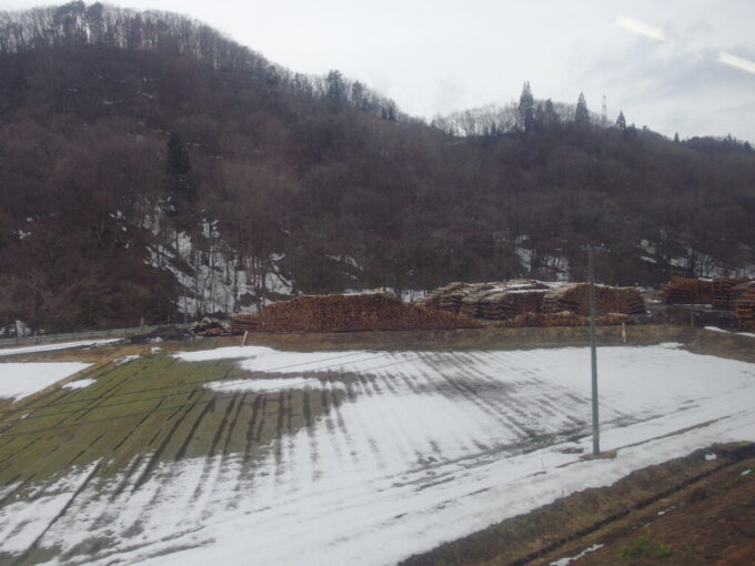 3月中旬春まだ浅い田沢湖線残雪と大量に杉が積まれた貯木場