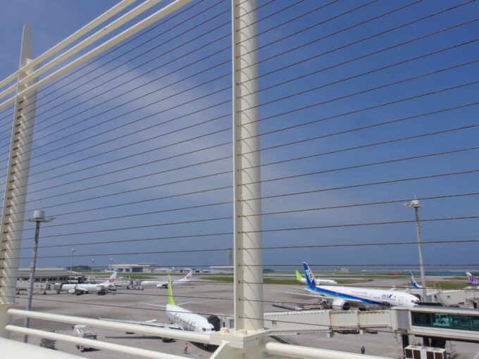 6月下旬梅雨明け間近の那覇空港展望デッキから望む飛行機と青い空