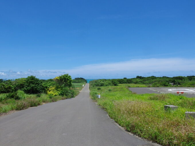 6月下旬梅雨明け直後の小浜島緑の茂る中のびる一本道の先には青く輝く海