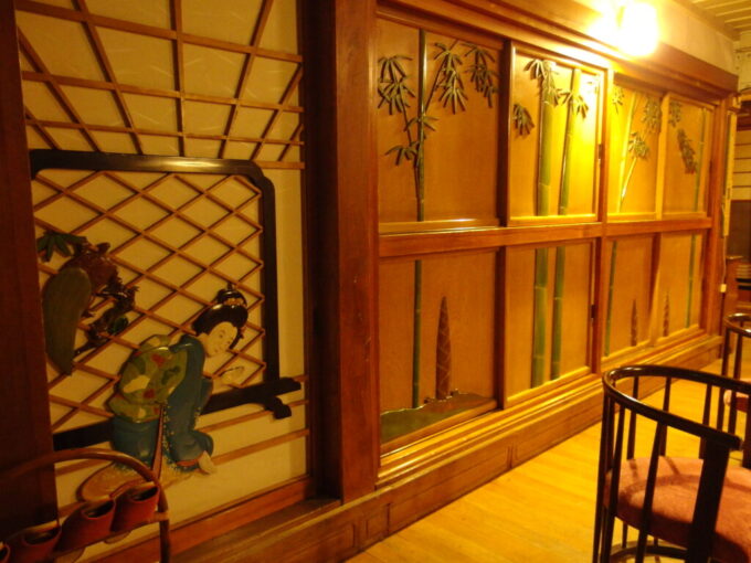 10月中旬初秋の瀬見温泉山形県最古の旅館建築喜至楼いらっしゃいませと客を出迎える女将の彫刻と引き戸に彫られた筍