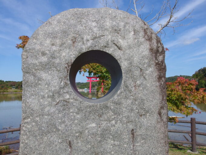 11月上旬奥房総亀山湖水天宮公園に建つ石のオブジェ越しに眺める赤鳥居