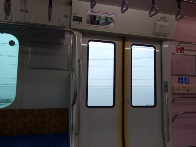 11月上旬雨の内房線外房線直通E131系上総一ノ宮行き普通列車車窓から眺める灰色の東京湾