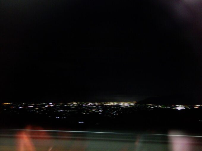 12月中旬夜のE353系中央本線特別急行あずさ号車窓に輝く甲府盆地の夜景
