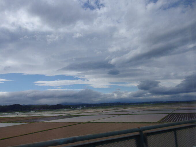 5月上旬曇天の東北新幹線E5系やまびこ号盛岡行き車窓から望む田植えに向け農作業中の田んぼ