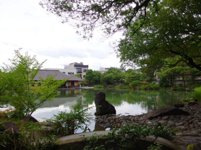 7月中旬の福井養浩館庭園景色を映す穏やかな池の水面