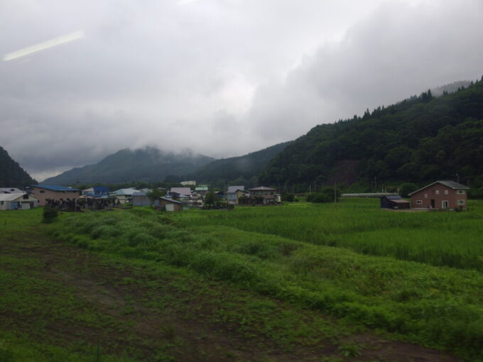 7月最終日奥羽本線701系弘前行き普通列車行く手の山並みは雨に煙る