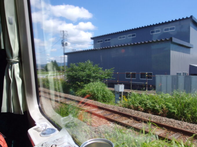 8月上旬夏の花輪線キハ110盛岡行き進行方向右手に見えてきた線路はスイッチバック後のこれから辿る鉄路