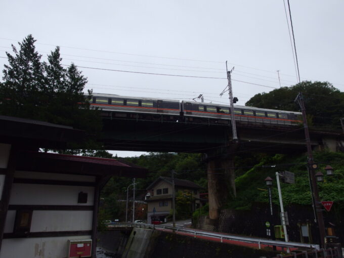 10月上旬旧中山道福島宿江戸時代の町並みが残ろ上ノ段の上空をかすめゆく中央西線特急しなの