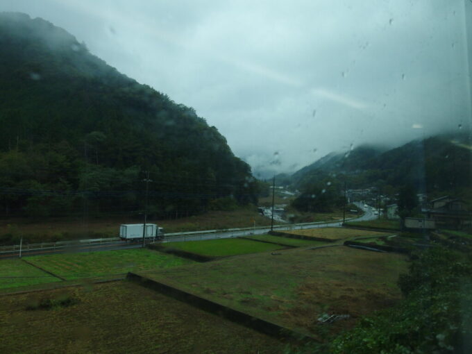 10月下旬雨の中央本線E353系特別急行かいじ号甲府行きは桂川の刻む谷筋を遡る