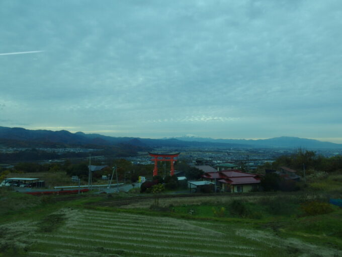 11月下旬山交バス蔵王温泉行き車窓から眺める蔵王の朱い鳥居と雪化粧をした月山