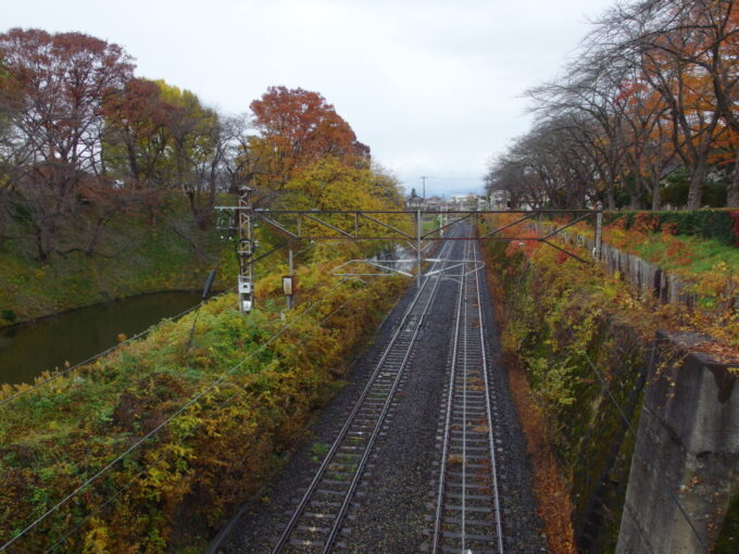 11月下旬晩秋の山形城跡霞城公園お堀端を走る山形新幹線と左沢線・仙山線の単線並列線路