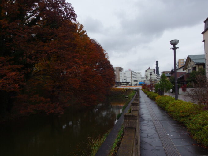 11月下旬晩秋の山形城跡霞城公園お堀の先に望む山形新幹線新型E8系