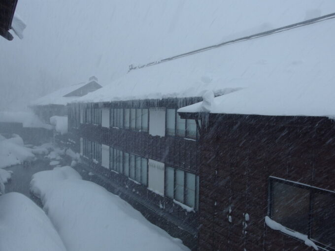 12月中旬冬の青森日本屈指の豪雪の地酸ヶ湯温泉旅館湯治棟6号館2階角部屋客室から望む雪に覆われた自炊棟の渋い佇まい