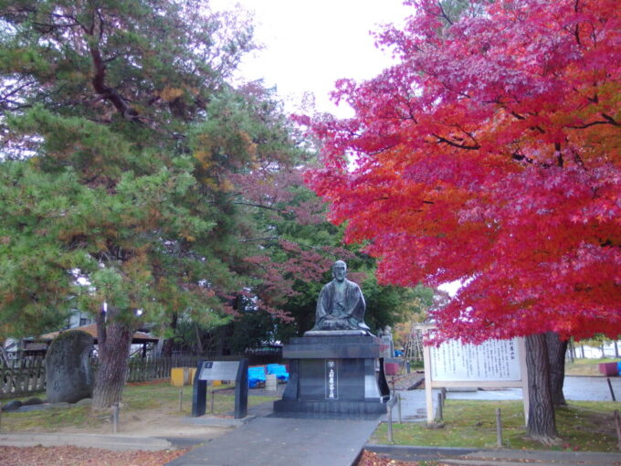 11月下旬晩秋の米沢城址松が岬公園に建つ上杉鷹山公の銅像と燃える紅葉