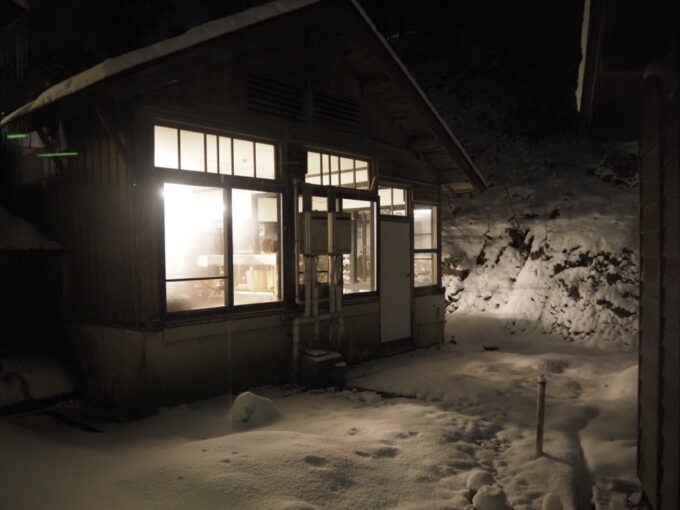 2月上旬厳冬期の花巻南温泉峡大沢温泉湯治屋夜の闇の中白く輝く雪と灯りを漏らす自炊部らしい調理場