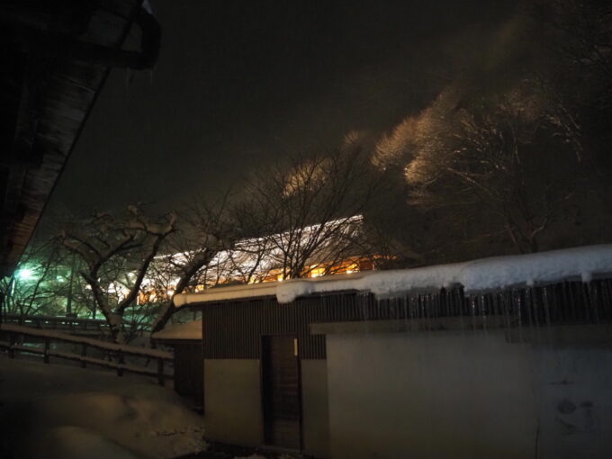 2月上旬厳冬期の花巻南温泉峡大沢温泉湯治屋中舘1階一号から眺める夜のライトアップされた茅葺屋根菊水舘