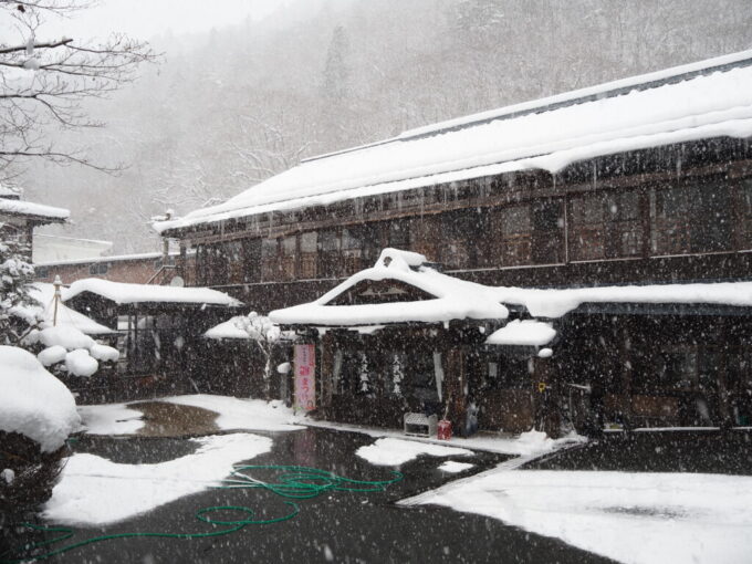 2月上旬厳冬期の花巻南温泉峡降りしきる雪の中佇む大沢温泉湯治屋自炊部本館