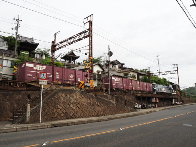 5月中旬の瀬戸内17年ぶりの尾道国道と並走する線路を走る貨物列車、その背後には古いお寺