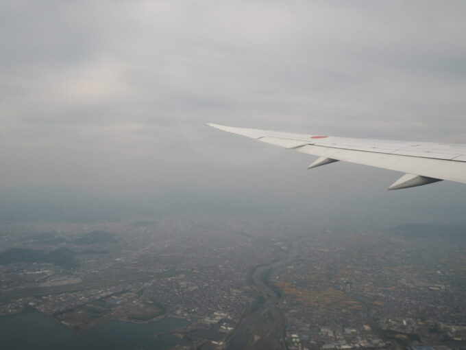 5月中旬の瀬戸内松山空港を離陸した羽田空港行きANAB787型機機窓には霞む松山の街並みが