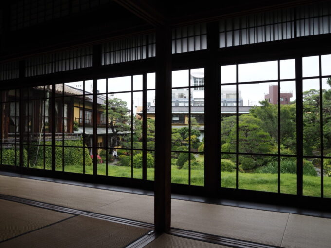 5月末雨上がりの熱海起雲閣麒麟から眺める古い硝子越しの新緑の庭園揺らぎある情景