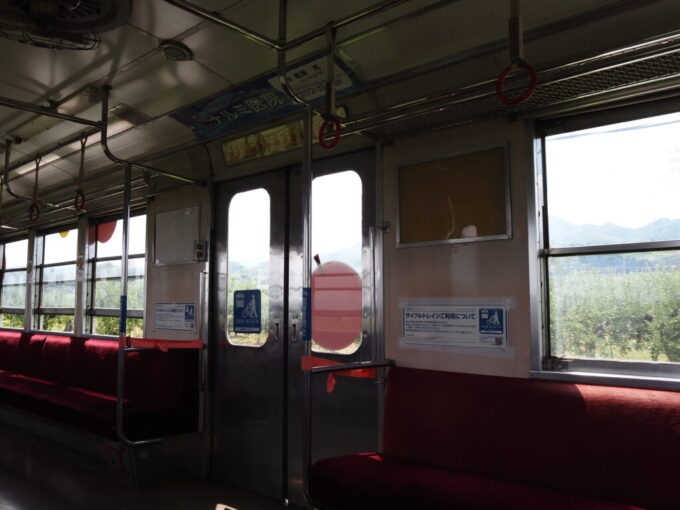 8月上旬夏の弘前弘南鉄道大鰐線りんご畑鉄道の名のとおり実をつけ始めたりんごの木々のなかを走るデハ7000系車窓