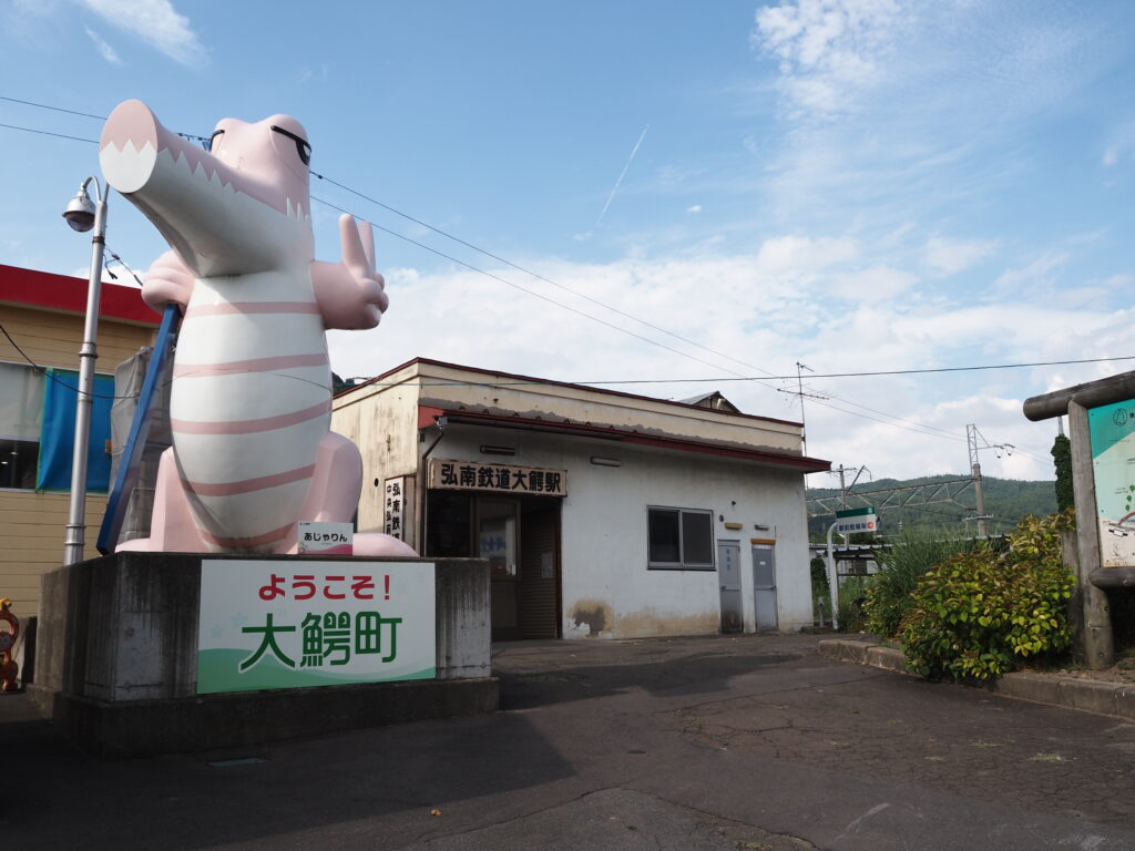 8月上旬夏の津軽JR大鰐温泉駅と弘南鉄道大鰐駅前に建つピンクのワニのあじゃりん