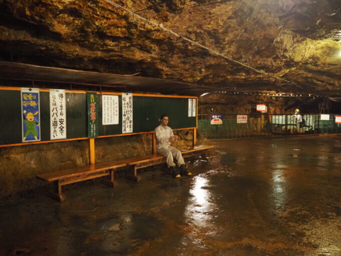 8月上旬夏の秋田鹿角花輪史跡尾去沢鉱山観光坑道石切沢通洞坑石切沢上部坑内事務所前のベンチに腰掛けるマネキン