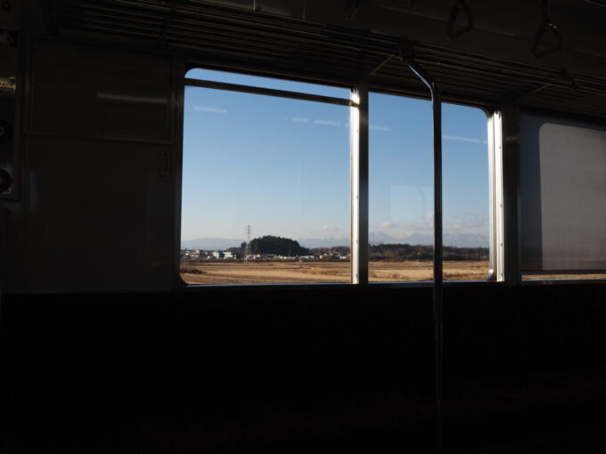 12月中旬初めての東武宇都宮線20400型普通新栃木行き車窓から眺める枯色の田園と日光の山並み