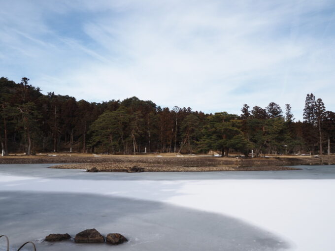 2月上旬冬の平泉毛越寺浄土庭園氷の上にうっすらと雪の積もる大泉が池の荘厳な世界観