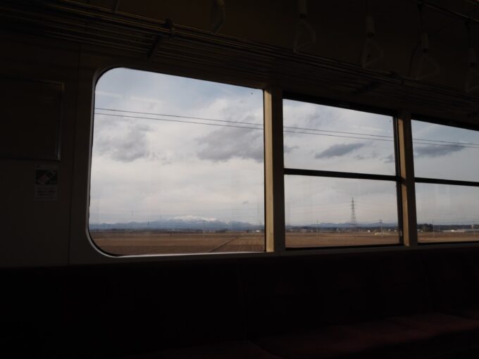 2月上旬冬の東北本線701系車窓から眺める雪をかぶった栗駒山