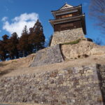 3月上旬初めての上田城跡芝生広場から見上げる荒々しい石垣と岩盤、南櫓の雄々しい姿