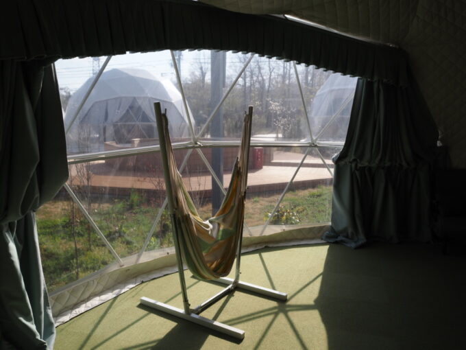 4月中旬那須温泉グランピングNenn（ネン）7ｍドームテントのLG-01冷暖房完備春の陽射しあふれるゆったりとした室内窓際に置かれたハンモック