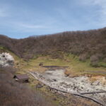 4月中旬春うららかな那須温泉神社の裏参道から荒涼とした殺生石園地を展望する