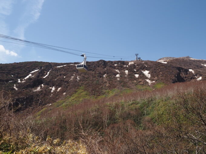 4月中旬春うららの那須茶臼岳9合目へと登る那須ロープウェイ山麓駅から昇ってゆく那須ロープウェイを見上げる