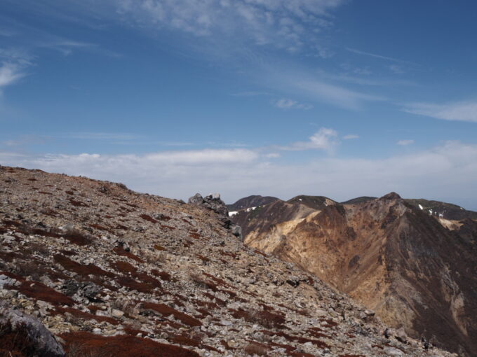 4月中旬春うららの那須岳主峰茶臼岳山頂へと向かう登山道から望む朝日岳の爆裂火口跡