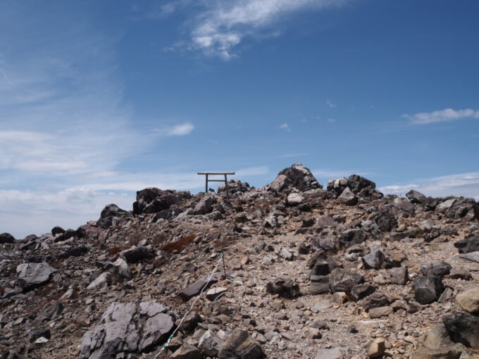 4月中旬春うららの那須岳主峰茶臼岳山頂へと向かう登山道行く手の西側を見ればついに鳥居の姿が