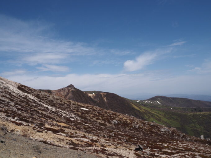 4月中旬春うららの那須岳主峰茶臼岳山頂へと向かう登山道から望む荒涼とした山肌と朝日岳