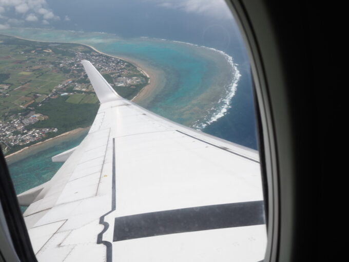 6月上旬いつもより半月早い八重山旅うちなーの翼JTA日本トランスオーシャン航空B737型機は那覇へと向け南ぬ島石垣空港を離陸機窓に広がる石垣島のうつくしい珊瑚礁