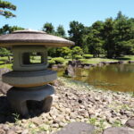 8月上旬夏の東北旅弘前藤田記念庭園池泉回遊式庭園の低地部の池に設けられた浅瀬と石灯籠